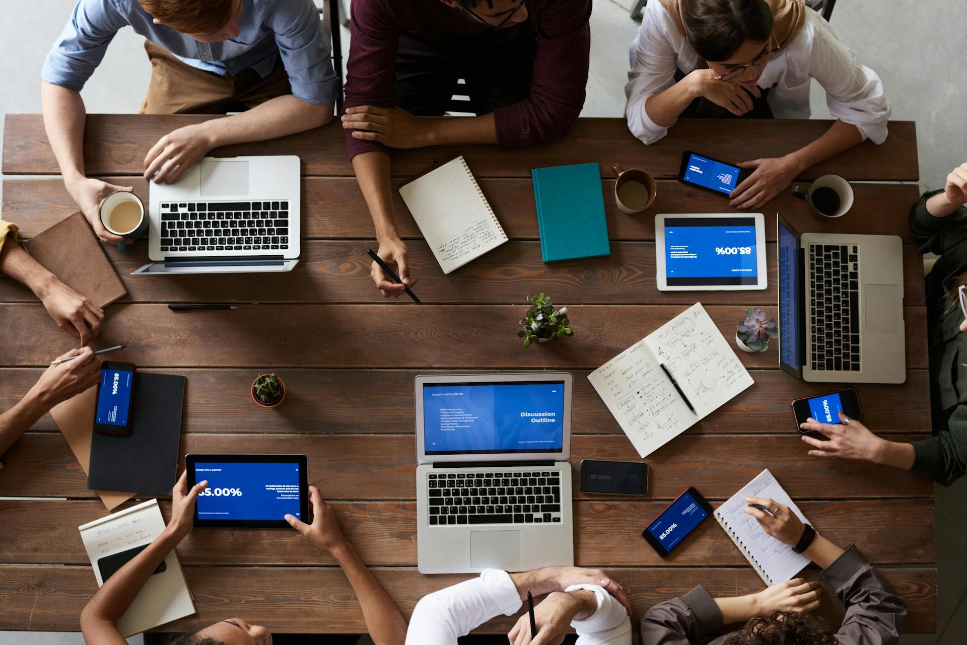 Picture of people working on computers around a desk